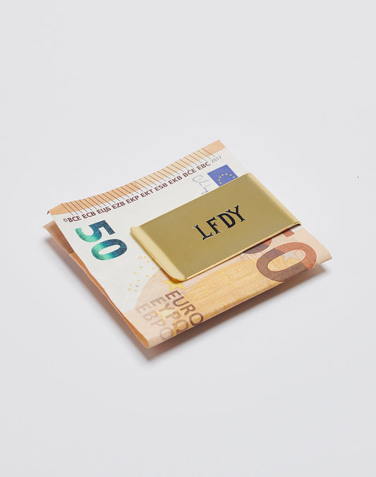 A gold Basic Money Clip by LIVE FAST DIE YOUNG (mod. LF2305-13647), aus Edelstahl mit graviertem Logo, hält gefaltete 10- und 20-Euro-Scheine auf weißem Hintergrund.