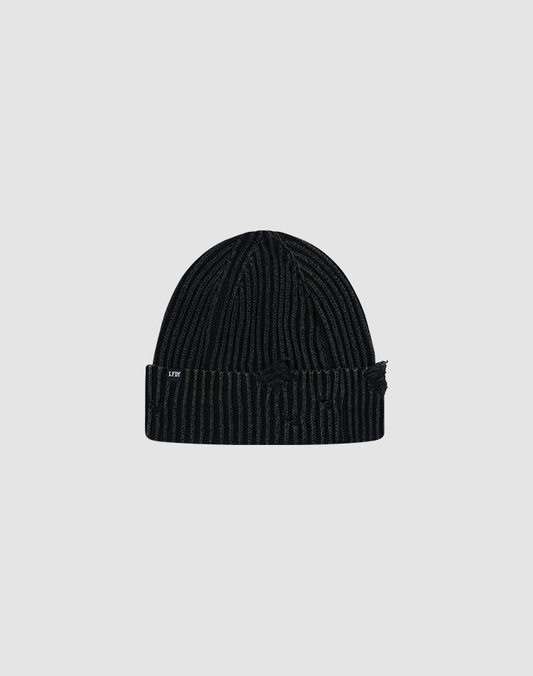 The LIVE FAST DIE YOUNG Distressed Rib Knit Beanie is a black 100% Baumwolle beanie with subtle vertical stripes, a folded brim, and a white LFW flag label on the side, shown on a plain light gray background.