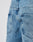 Close-up of the back of a person wearing LFDY Baggy Denim by LIVE FAST DIE YOUNG in light blue, featuring a baggy fit with wide straight legs, two back pockets, and a small black fabric tag on the right pocket.