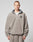A person with short hair wears the LIVE FAST DIE YOUNG Live Fast Fleece Halfzip, a loose, light gray fleece half-zip pullover with an oversized fit and small left chest logo, standing against a plain light background.