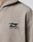 Close-up of the Live Fast Fleece Halfzip by LIVE FAST DIE YOUNG, shown in an oversize fit light gray with a black and white chest patch displaying a stylized graphic and bold LIVE FAST text. Only part of the hoodie is visible.