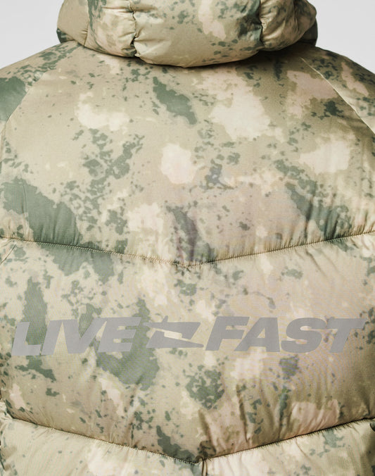A close-up of the LIVE FAST DIE YOUNG Live Fast Puffer Jacket in green and beige camo with an oversize fit, bold gray LIVE FAST lettering on the back, and reflektierender Front- und Backprint for extra style.