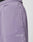 Close-up of a person wearing LIVE FAST DIE YOUNG Basic Wide Jogger in light purple cotton. Features side pockets, ribbed elastic waistband, and Live Fast embroidered in white near the hip. A hint of black undergarment is visible at the waist.