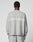 A person faces away in a light gray, oversize Live Fast Boucle Sweater by LIVE FAST DIE YOUNG, featuring “LIVE FAST” in white on the back. Made from 100% polyester and paired with matching gray pants.