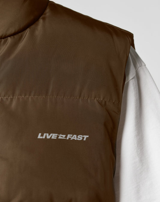 A close-up of the brown Live Fast Cropped Vest by LIVE FAST DIE YOUNG, with LIVE FAST in white on the chest, featuring große aufgesetzte Taschen and worn over a white shirt.