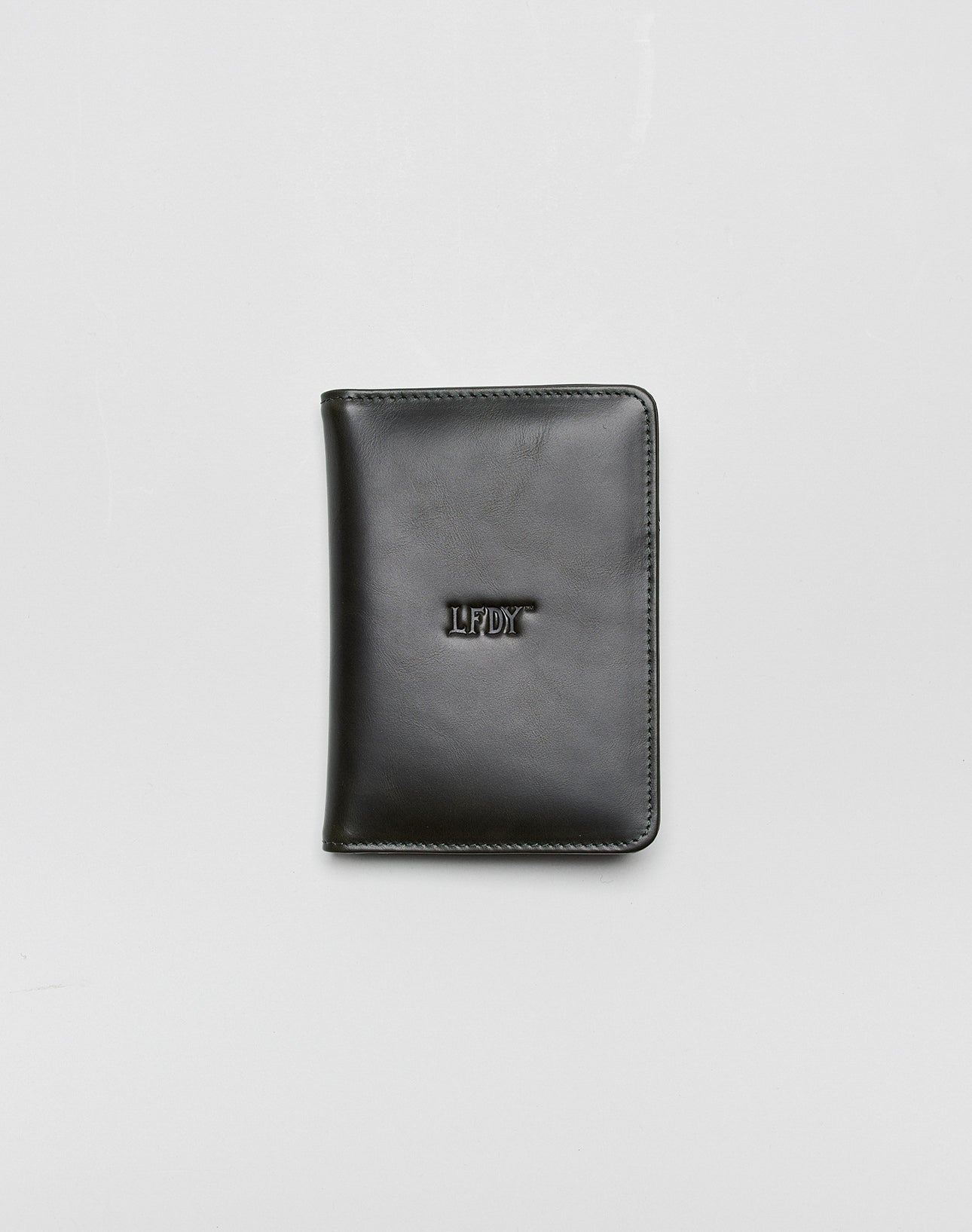 A closed black LFDY Passport Case by LIVE FAST DIE YOUNG with rounded corners, center LFDY embossing, and multiple card slots, shown on a plain light gray background.