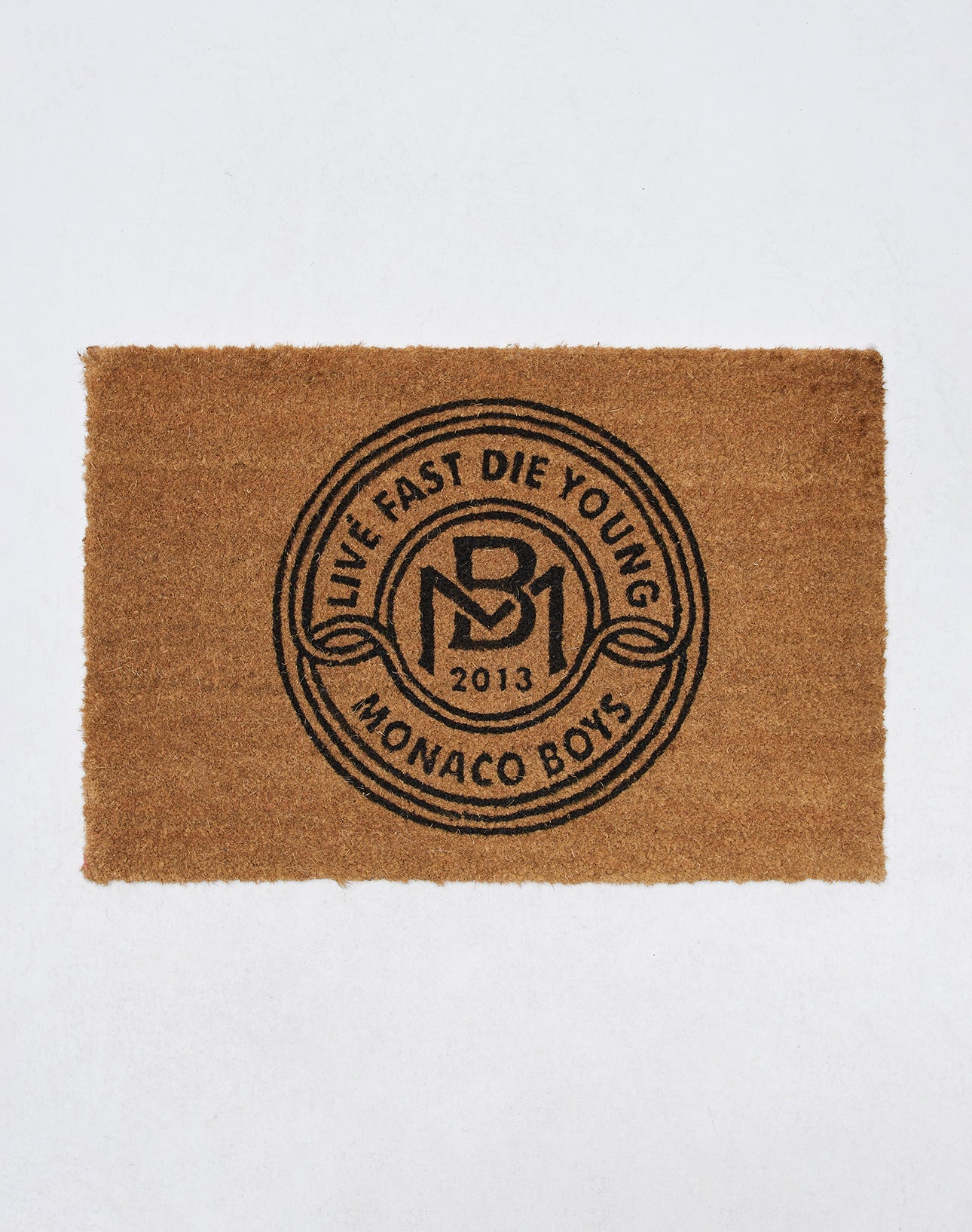 Die Monaco Boys Doormat von LIVE FAST DIE YOUNG ist eine braune Kokosfaser-Fußmatte mit schwarzem kreisförmigem Design und eignet sich ideal für drinnen und draußen auf schlichtem weißen Hintergrund.