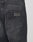 Close-up of the back pocket on LIVE FAST DIE YOUNG Regular Denim jeans. The black 100% cotton denim shows a worn texture, and a rectangular Lederpatch with LFDT is embossed above the pocket.