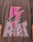 A person wears the LFDY Flash Tee by LIVE FAST DIE YOUNG—an oversized brown Cotton-Slub shirt with a large pink lightning bolt and bold LIVE FAST prints front and back, featuring a dynamic cracked effect around the text.