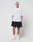 A person with short blond hair stands against a plain white background, wearing the LIVE FAST DIE YOUNG Basic 280 Tee in an oversize fit, paired with black shorts, white socks, and sneakers. Their hands are in their pockets and they have a neutral expression.