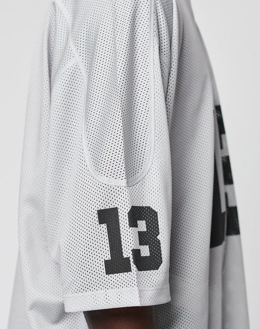 A close-up side view of a person wearing the LFDY Mesh Jersey by LIVE FAST DIE YOUNG, featuring white polyester mesh fabric and bold black number 13 printed on the sleeve.