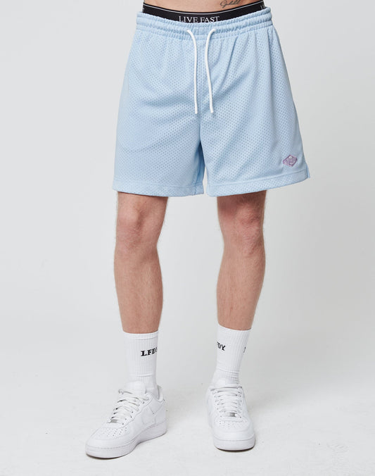 A person wearing light blue Basic Mesh Shorts from LIVE FAST DIE YOUNG with an elastic waistband, white socks with LFDY text, and white sneakers, standing against a plain white background.
