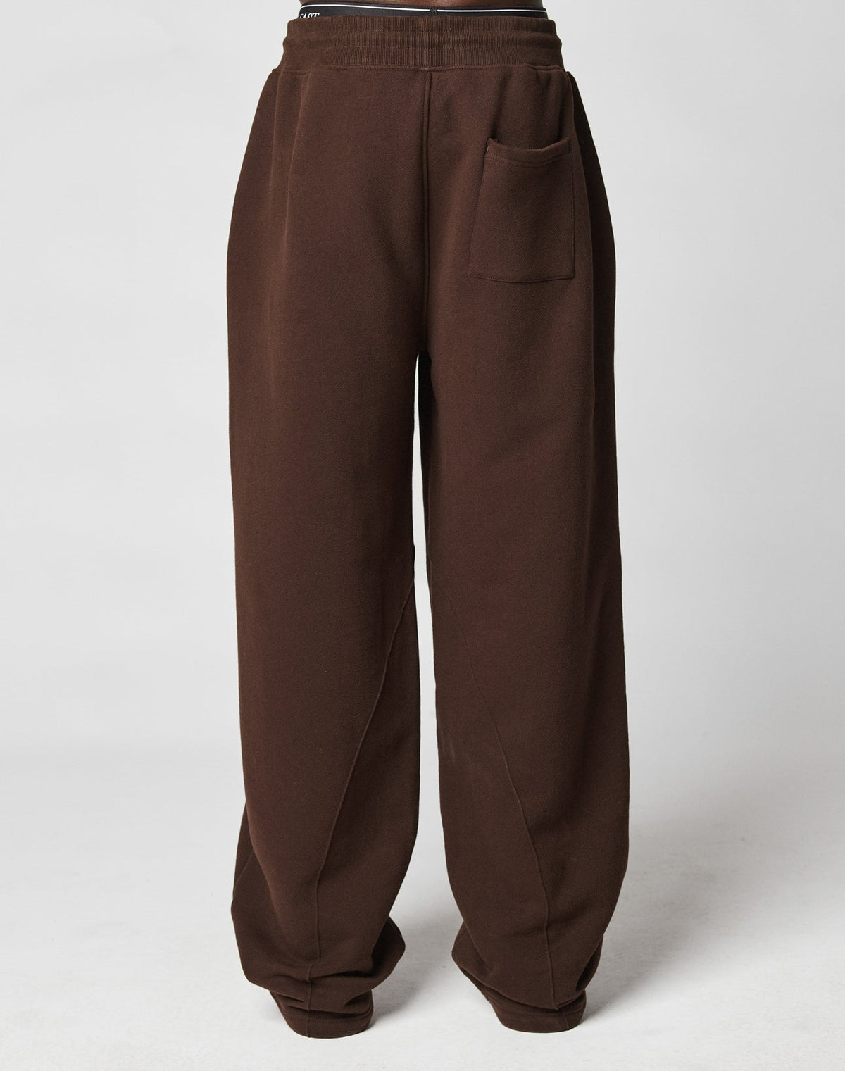 The LFDY Pleated Jogger by LIVE FAST DIE YOUNG features a loose fit, dark brown color, single front pocket, and comfortable elastic waistband, displayed on a plain white background.
