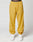 A person wearing mustard yellow LFDY Trackpants by LIVE FAST DIE YOUNG, featuring branding on the elastic waistband and left thigh, paired with white sneakers, stands against a plain white background.