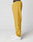 A person in LIVE FAST DIE YOUNG LFDY Trackpants—mustard yellow with Elastikbund and reflective Live Fast print—stands sideways in white sneakers against a plain white background, showing only the lower body.