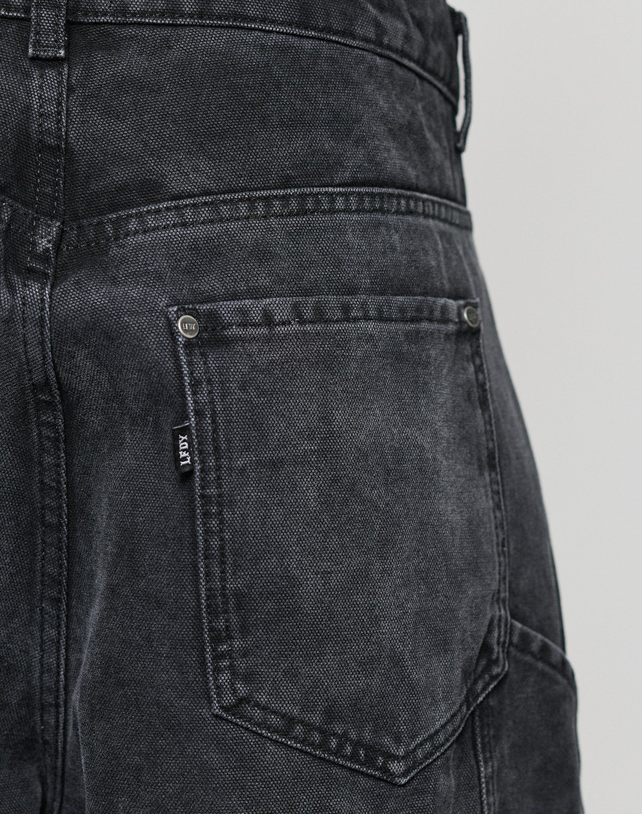 Close-up of the back pocket on LFDY Carpenter Pants from LIVE FAST DIE YOUNG, featuring a small seam label and detailed stitching for an authentic carpenter-inspired style.
