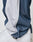 Close-up of a person wearing LIVE FAST DIE YOUNG LFDY DY Trackpants made of soft polyester with an Elastikbund. The blue pants have a white stripe and bunch slightly at the ankle, covering part of white sneakers.