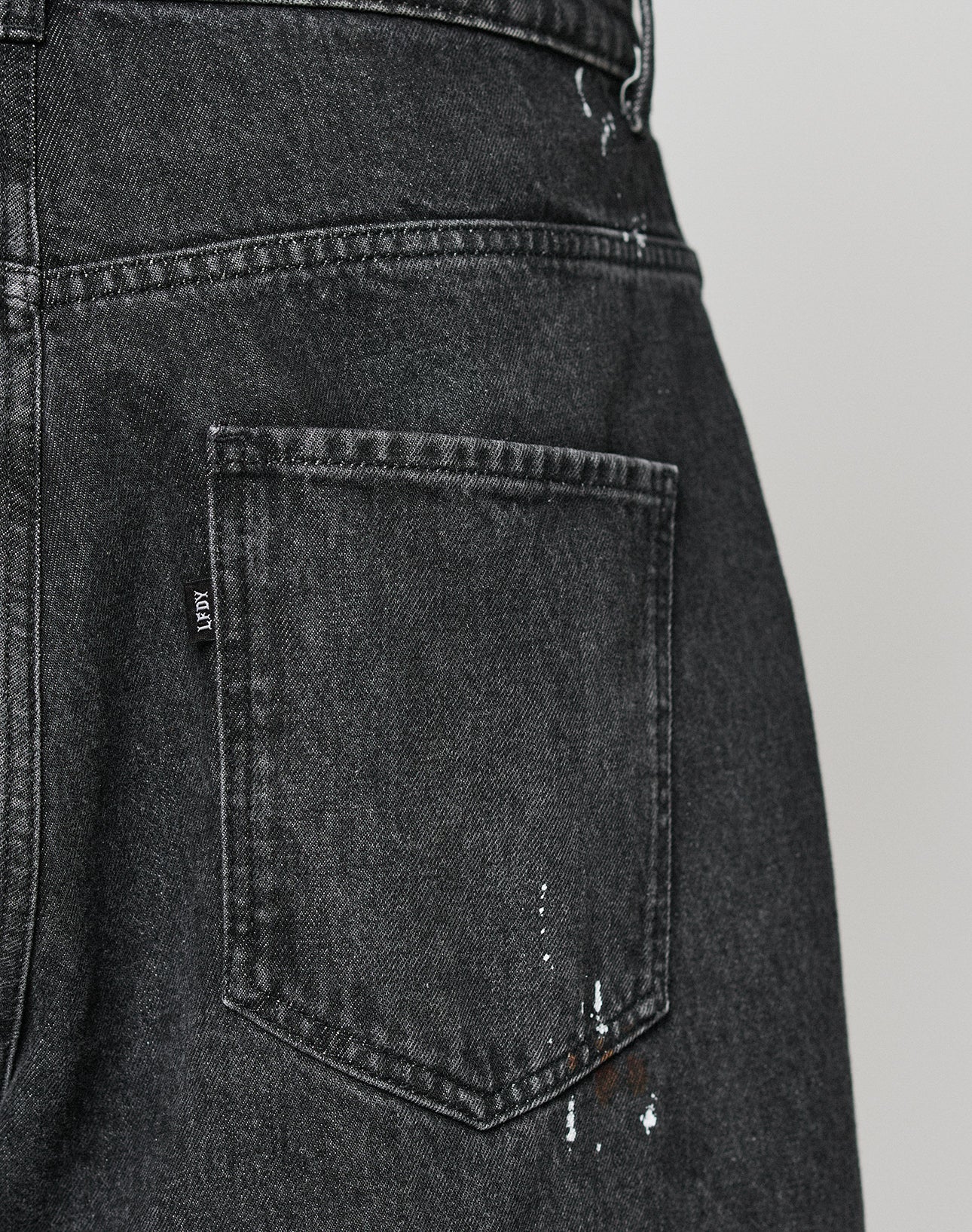 Close-up of the back pocket on LIVE FAST DIE YOUNGs LFDY Baggy Denim, featuring splashes of color near the bottom and showcasing their signature baggy fit style.