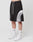 A person wears LIVE FAST DIE YOUNG Basic Trackshorts in black and white with an elastic waistband, paired with white LFDY socks and white Nike sneakers, standing against a plain white background.
