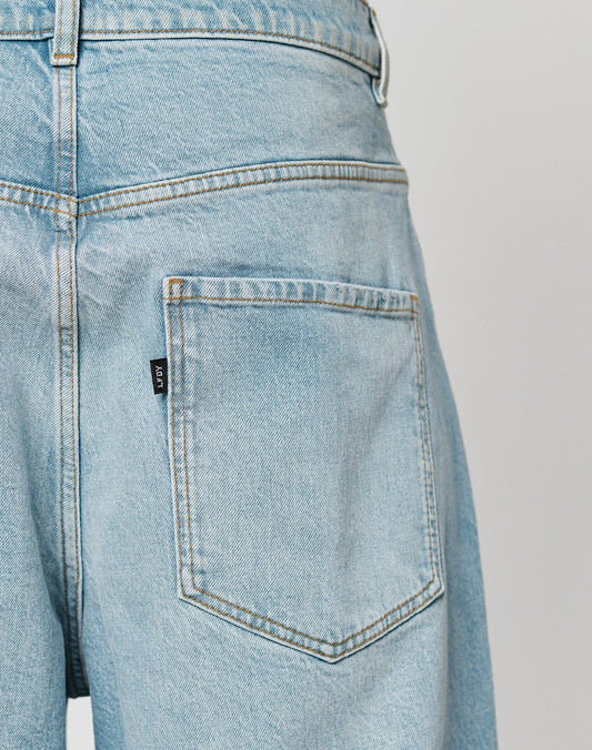 Close-up of the back pocket on LIVE FAST DIE YOUNG’s LFDY Baggy Denim jeans in light blue, highlighting stitching detail and a black side label. Made from 100% Baumwolle for comfort and durability.