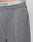 Close-up of a person in Wide Casual Pants by LIVE FAST DIE YOUNG, featuring a straight leg and subtle pleats. The elastic waistband of white underwear with LIVE FAST in black shows above the pants.