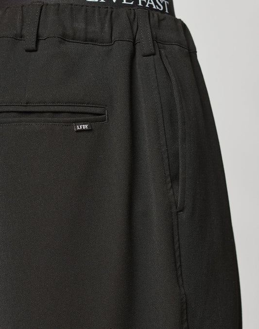 Close-up of Wide Casual Pants by LIVE FAST DIE YOUNG with side pockets, a back pocket featuring a small LFDY label, and an elastic waistband showing LIVE FAST text. Wide Fit offers relaxed comfort and modern style.