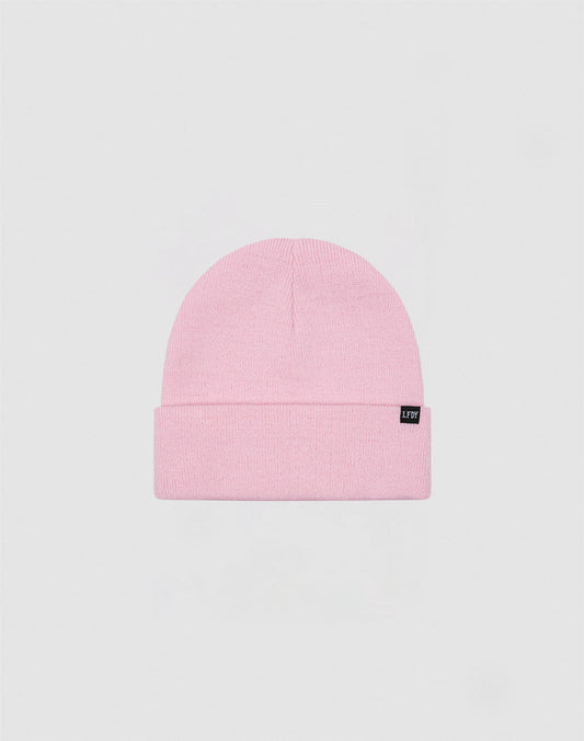 The LIVE FAST DIE YOUNG Basic Beanie in light pink polyacryl features a folded brim and a small black flag label on the front, shown against a plain light gray background.
