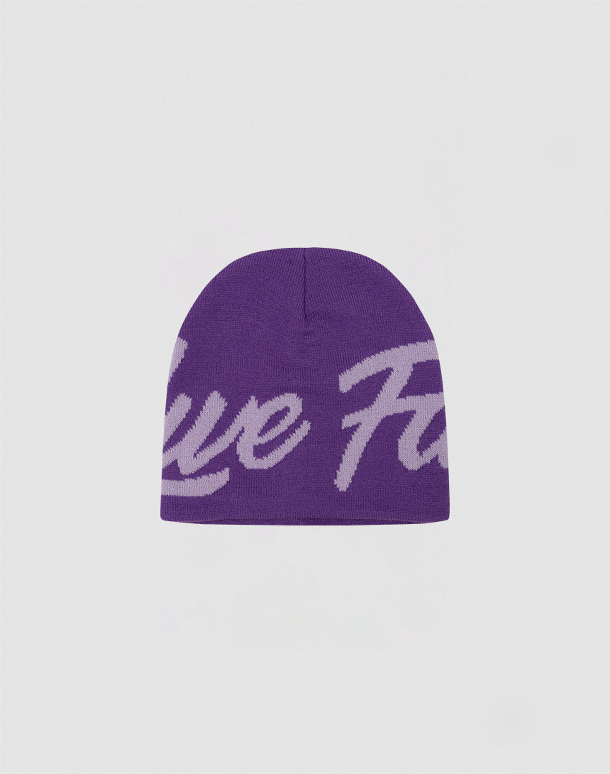 The LFDY Jacquard Beanie by LIVE FAST DIE YOUNG is a purple Polyacryl knit beanie with large light lavender Logo Strick script, shown on a plain light gray background. Style code: LF2411-16806.