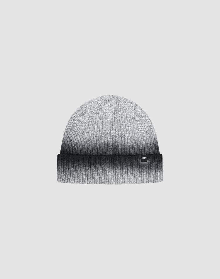 The LIVE FAST DIE YOUNG "Live Fast Boucle Beanie" is a gray knitted hat with a folded brim, subtle Sprayeffekt gradient from light to dark gray, and a discreet Flag-Label, shown against a plain light background.| plain 