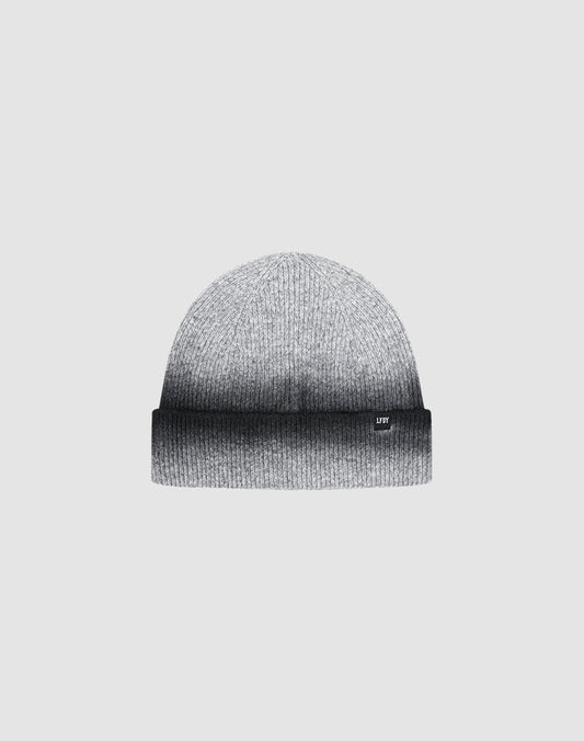 The LIVE FAST DIE YOUNG "Live Fast Boucle Beanie" is a gray knitted hat with a folded brim, subtle Sprayeffekt gradient from light to dark gray, and a discreet Flag-Label, shown against a plain light background.| plain 