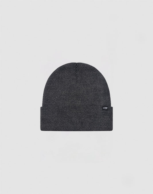 The LIVE FAST DIE YOUNG Basic Beanie is a dark gray cotton hat with a folded brim and a small rectangular tag on the left side, shown on a light gray background. Care instructions are provided for easy maintenance.