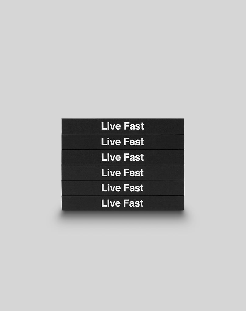 Six black hardcover LFDY Brand Bible books from LIVE FAST DIE YOUNG are stacked horizontally, each boldly displaying Live Fast in white letters against a plain light gray background.