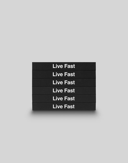 Six black hardcover LFDY Brand Bible books from LIVE FAST DIE YOUNG are stacked horizontally, each boldly displaying Live Fast in white letters against a plain light gray background.