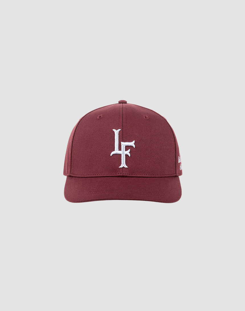 The LF Snapback by LIVE FAST DIE YOUNG is a maroon cotton baseball cap featuring a white LF logo embroidered on the front, shown against a light gray background. It includes a snap closure for an adjustable fit.