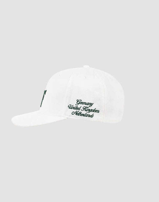 The LF Snapback by LIVE FAST DIE YOUNG is a white cotton baseball cap with green Logo-Stick text—Germany, United Kingdom, Netherlands—on the side and a snap closure, shown on a light gray background.