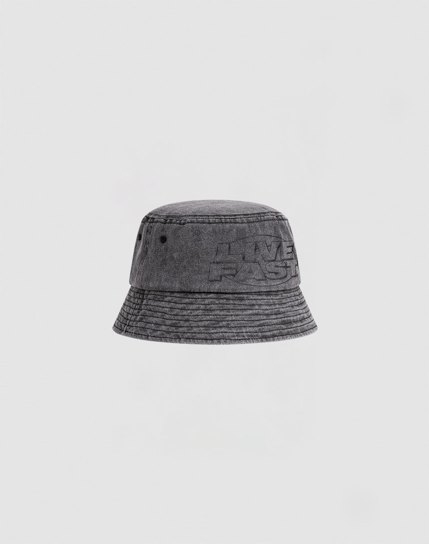The LFDY Oval Bucket Hat by LIVE FAST DIE YOUNG is a gray denim hat made from 100% Baumwolle, featuring visible stitching, subtle LIVE FAST embroidery on the front, and a vintage Waschung, shown on a plain white background.