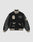The LIVE FAST DIE YOUNG LFDY x Schott NYC Varsity Jacket is a limited edition black jacket with cream accents, leather sleeves, embroidered patches and text, plus striped cuffs, collar, and hem.