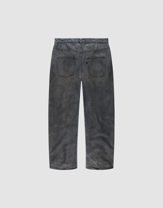 Back view of the LIVE FAST DIE YOUNG LFDY Coated Baggy Denim in faded black, made from 100% Baumwolle, featuring a baggy fit, two back pockets, and subtle paint splatters on a plain light gray background.