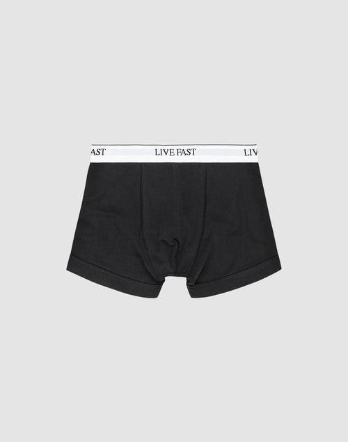 LIVE FAST DIE YOUNG Live Fast Trunks (2 Pack): Black mens boxer briefs made from cotton, with a white elastic waistband featuring LIVE FAST in black text, shown on a plain light gray background. 