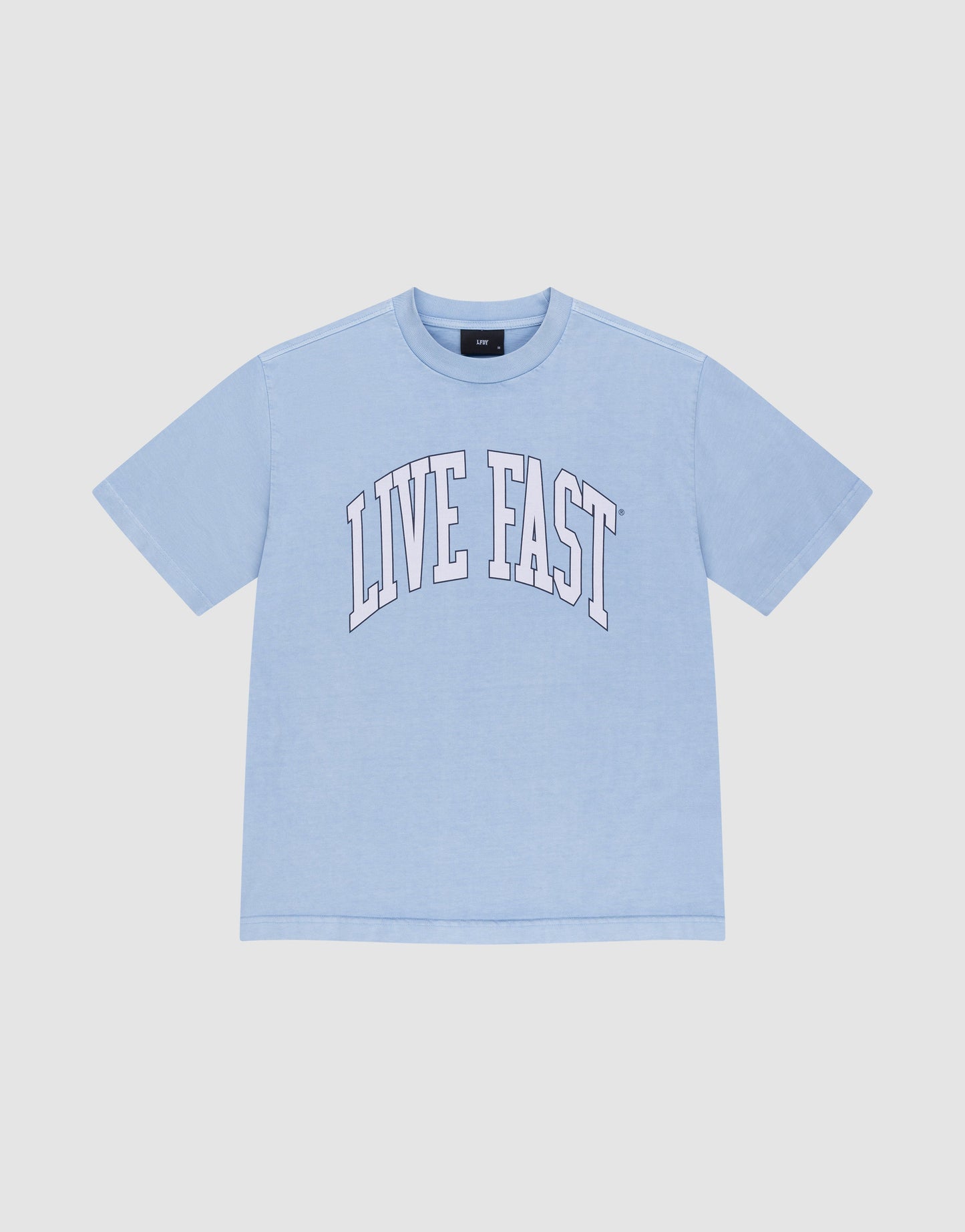 The LIVE FAST DIE YOUNG Live Fast College Tee is a light blue, 100% Baumwolle oversize short-sleeve shirt with "LIVE FAST" in large white arched letters on the front, shown on a plain white background.