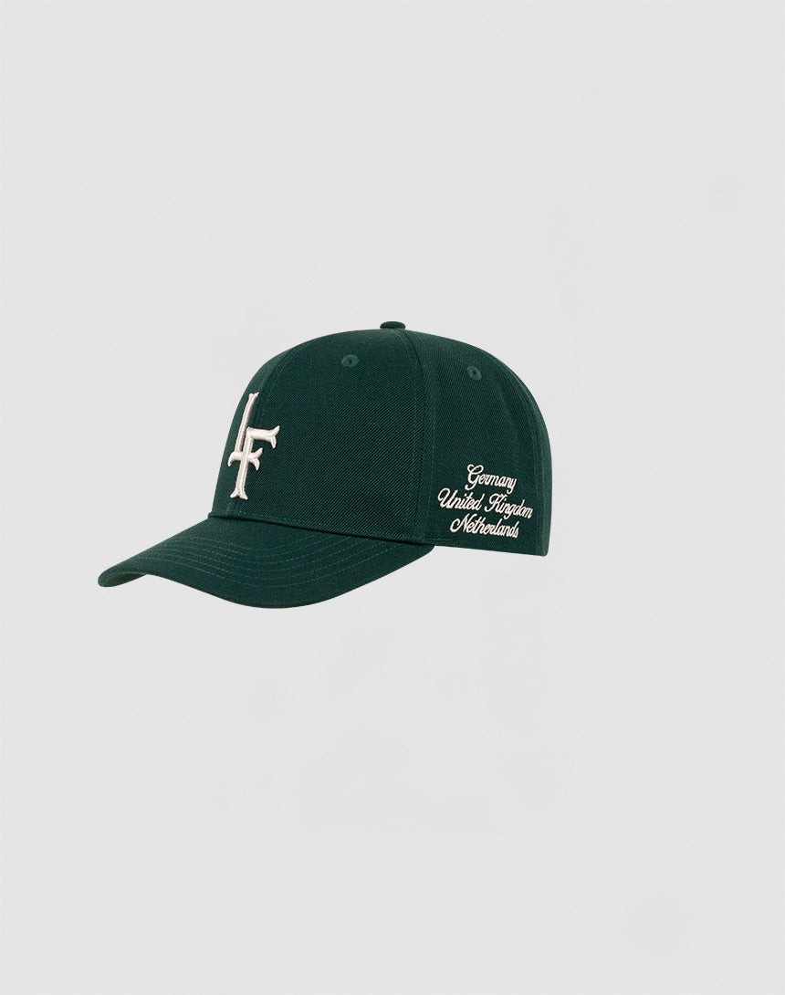 A dark green LF Snapback by LIVE FAST DIE YOUNG features multi-logo stick details, a white stylized LF logo on the front, and cursive side text reading Germany World Together Netherlands. Modell: LF2308-14417.