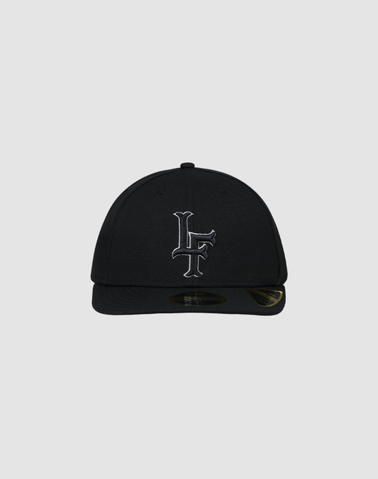 A black LFDY X NEW ERA 59FIFTY Low Profile fitted cap by LIVE FAST DIE YOUNG, featuring a flat brim and white LF initials embroidered on the front, displayed against a plain gray background.| plain 