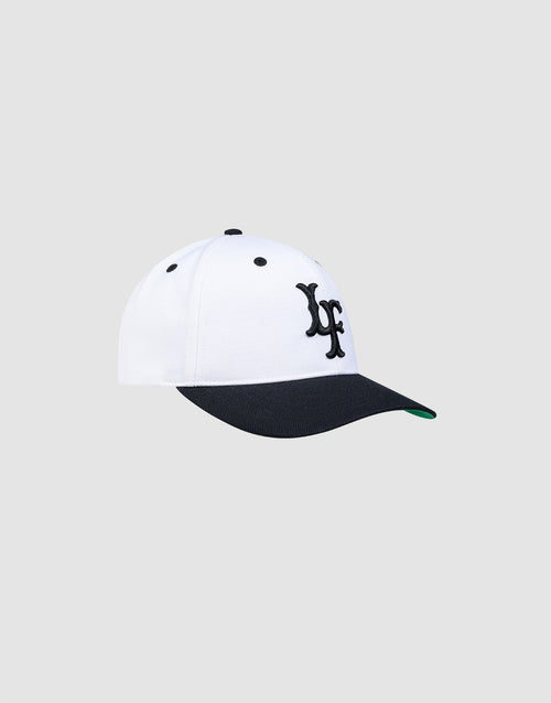 The LFDY Snapback by LIVE FAST DIE YOUNG features a white crown, black curved brim, green underside, and black embroidered "yf" on the front with a practical snap closure. Displayed against a plain light gray background.