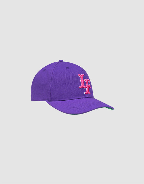 The LFDY Snapback by LIVE FAST DIE YOUNG is a purple cap with a curved brim, green underside, embroidered pink and white LF logo on the front, and Snapverschluss, shown against a plain light gray background.