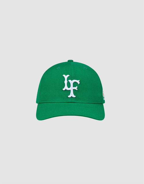 The LFDY Snapback by LIVE FAST DIE YOUNG features a green design with white LF embroidery on the front, matching green underbill, and an adjustable snap closure, shown against a plain light gray background. 
