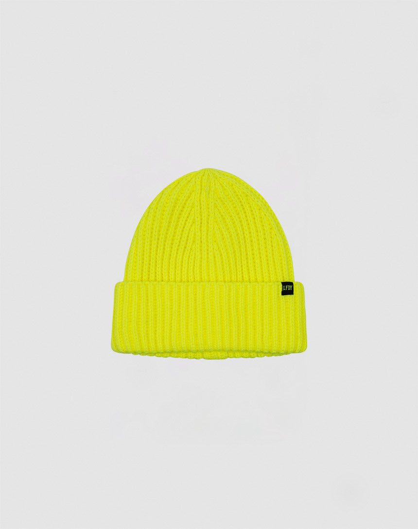 The Rib Knit Beanie by LIVE FAST DIE YOUNG is a bright yellow Polyacryl hat in ribbed knit, with a folded brim and a small black side tag, shown on a plain light grey background.
