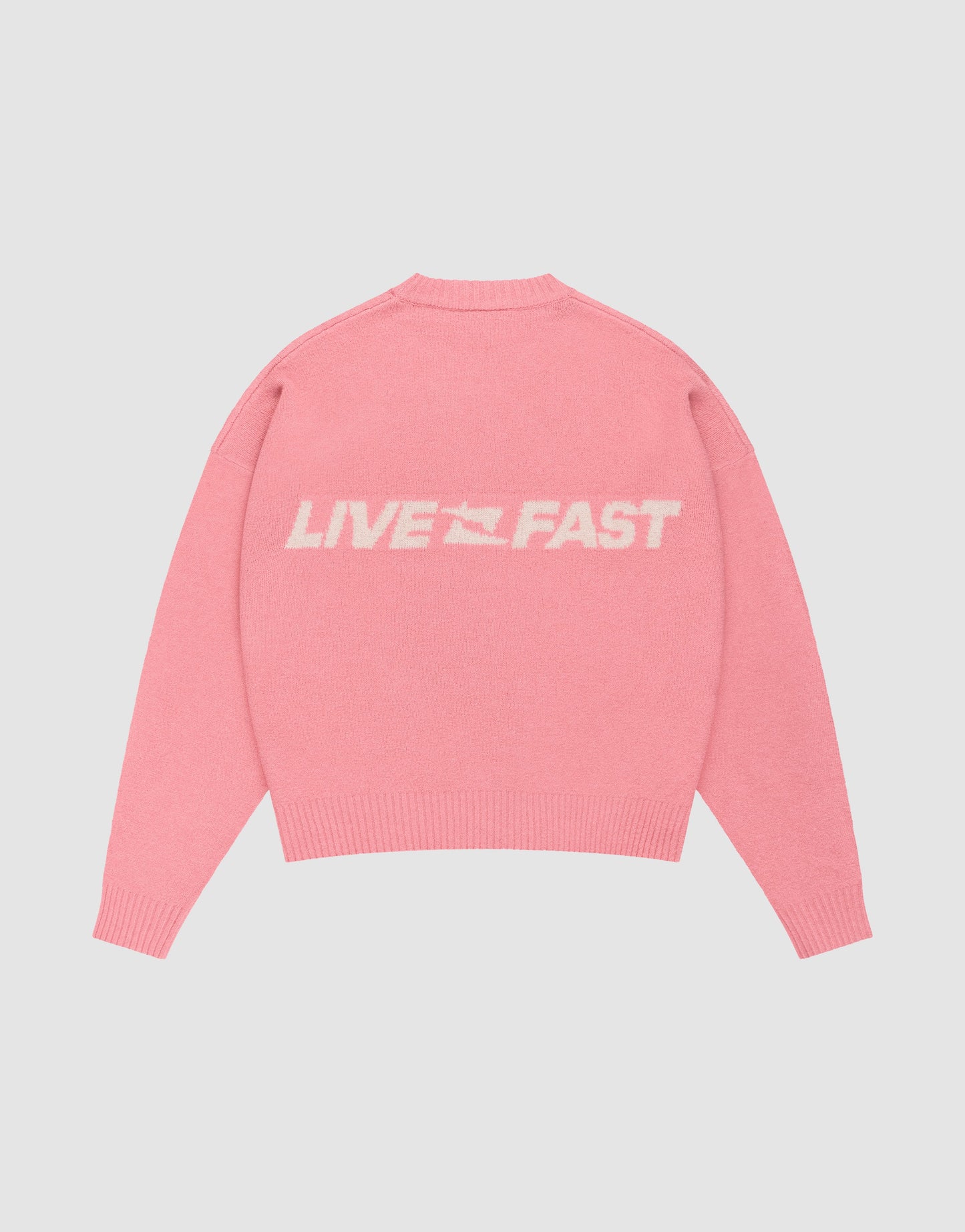 The Live Fast Boucle Sweater by LIVE FAST DIE YOUNG is an oversize pink knit featuring "LIVE FAST" text and a small white graphic on the back.