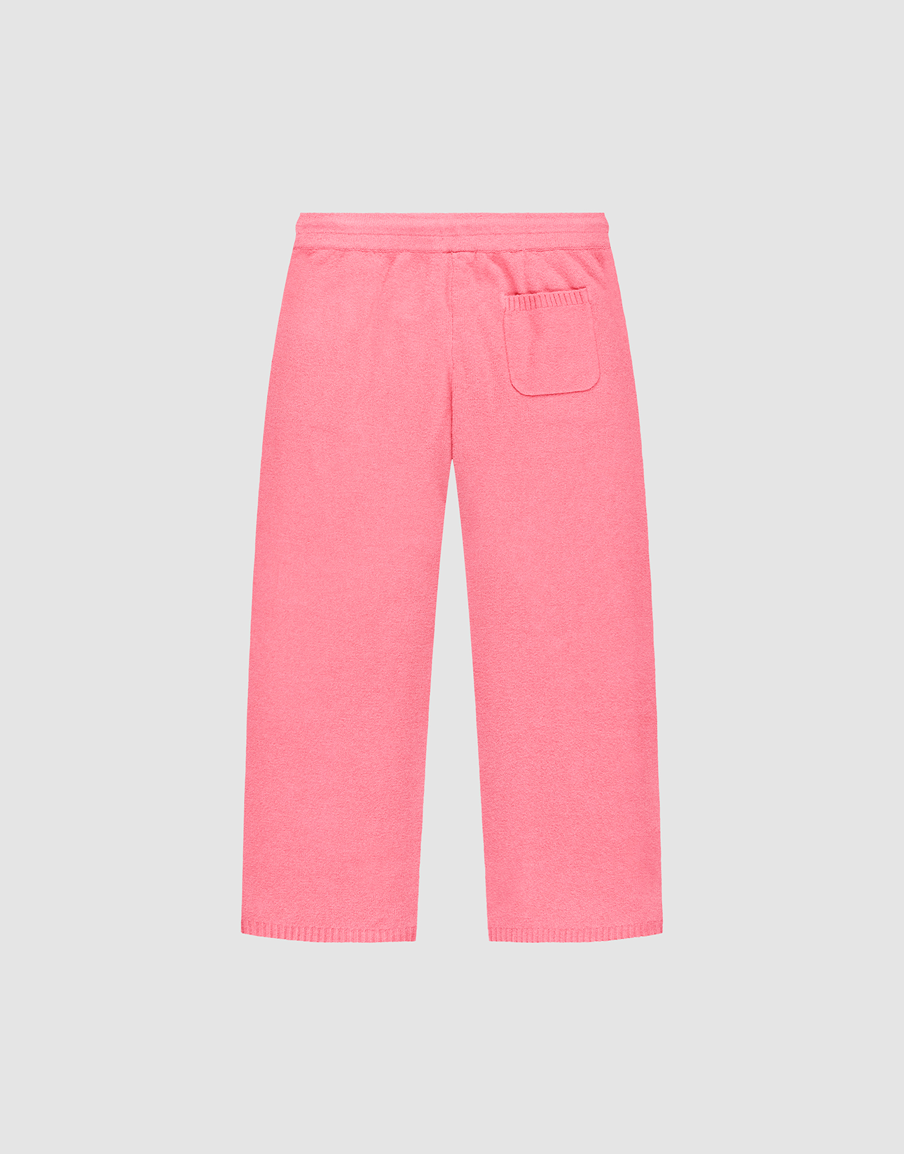 The Live Fast Boucle Pants by LIVE FAST DIE YOUNG are pink terry cloth lounge pants featuring a Wide Fit, elastic waistband, straight legs, and a single right patch pocket, shown against a plain light gray background.