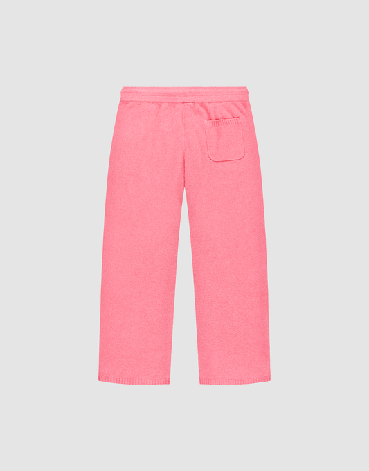 The Live Fast Boucle Pants by LIVE FAST DIE YOUNG are pink terry cloth lounge pants featuring a Wide Fit, elastic waistband, straight legs, and a single right patch pocket, shown against a plain light gray background.