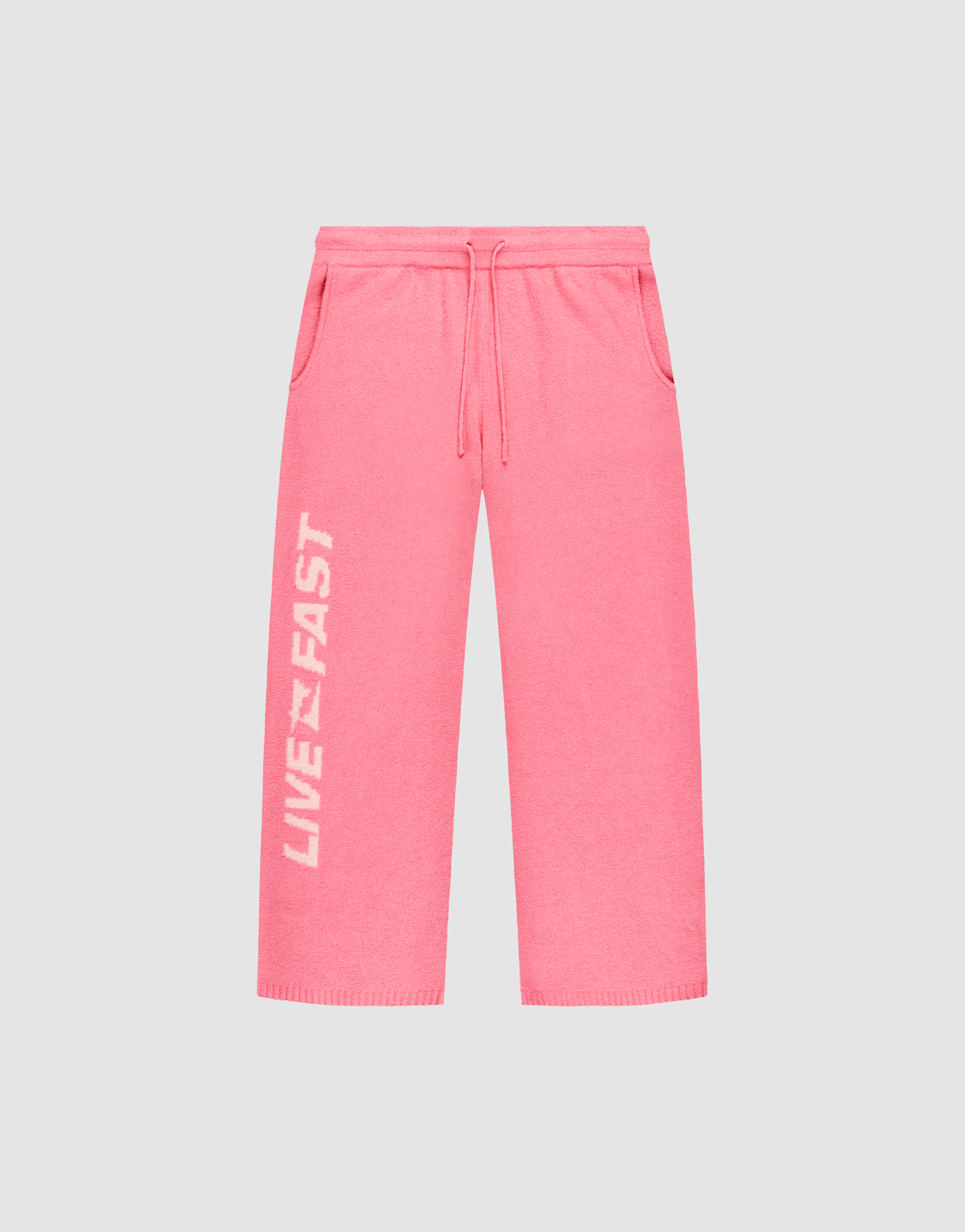 The Live Fast Boucle Pants by LIVE FAST DIE YOUNG feature a bright pink wide fit, elastic waistband, side pockets, and “LIVE FAST” in bold white text vertically on the left leg. | plain